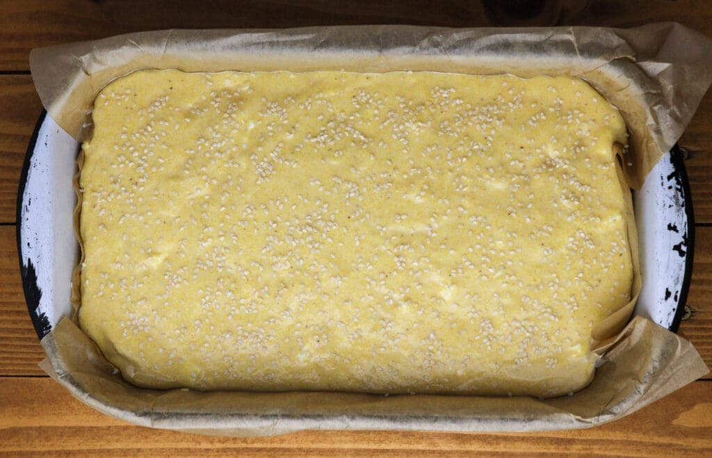 image of polenta bread batter sprinkled with sesame seeds